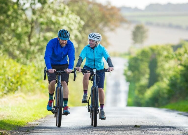 Two cyclists on road bikes, cycling in Croxton, Lincolnshire.